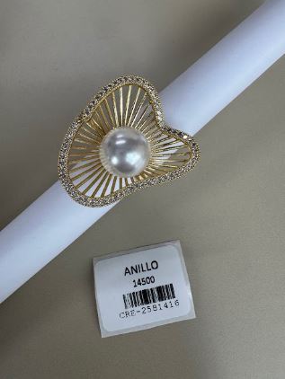 Anillo dorado con diseño radiante y perla central